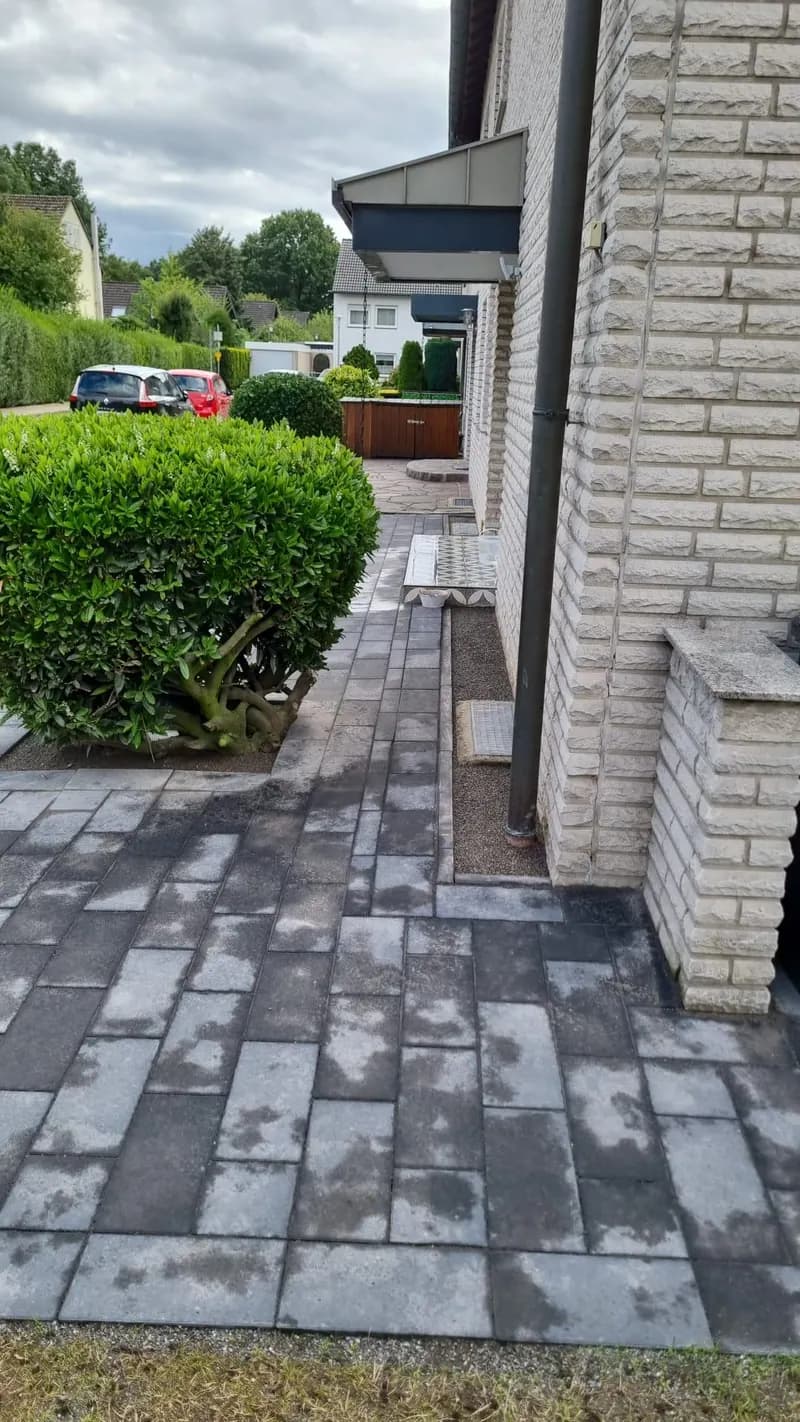 Gepflasterter Weg entlang der Hauswand