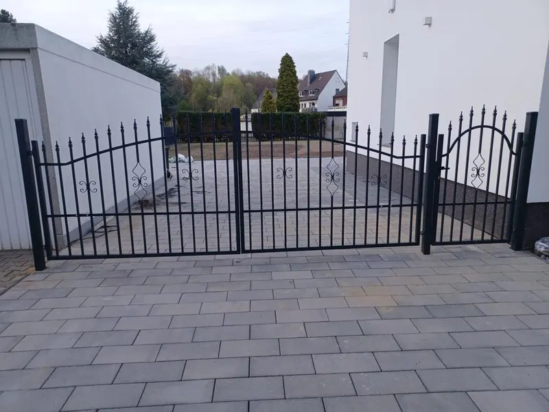 Schmiedeeisernes Hoftor vor der neu gepflasterten Fläche