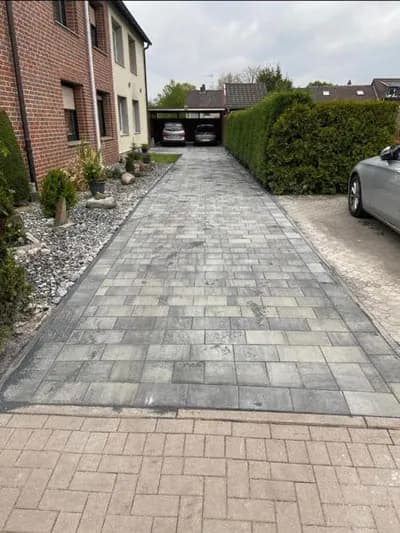 Gepflasterte Einfahrt zwischen Wohnhaus und Heckenreihe
