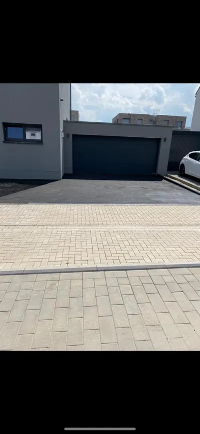 Gepflasterte Zufahrt vor der Garage eines Neubaus