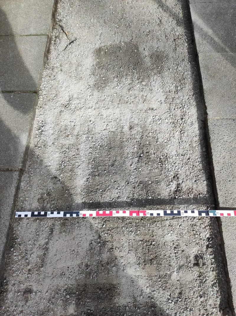 Verfüllter Grabenstreifen mit angelegtem Maßband zur Dokumentation der Breite