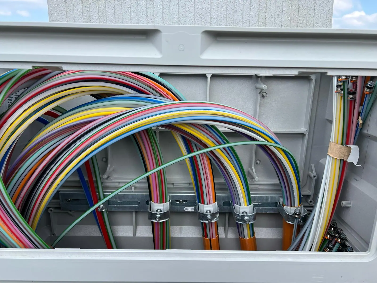 Bündel farbiger Glasfaserleitungen in einem Netzverteiler