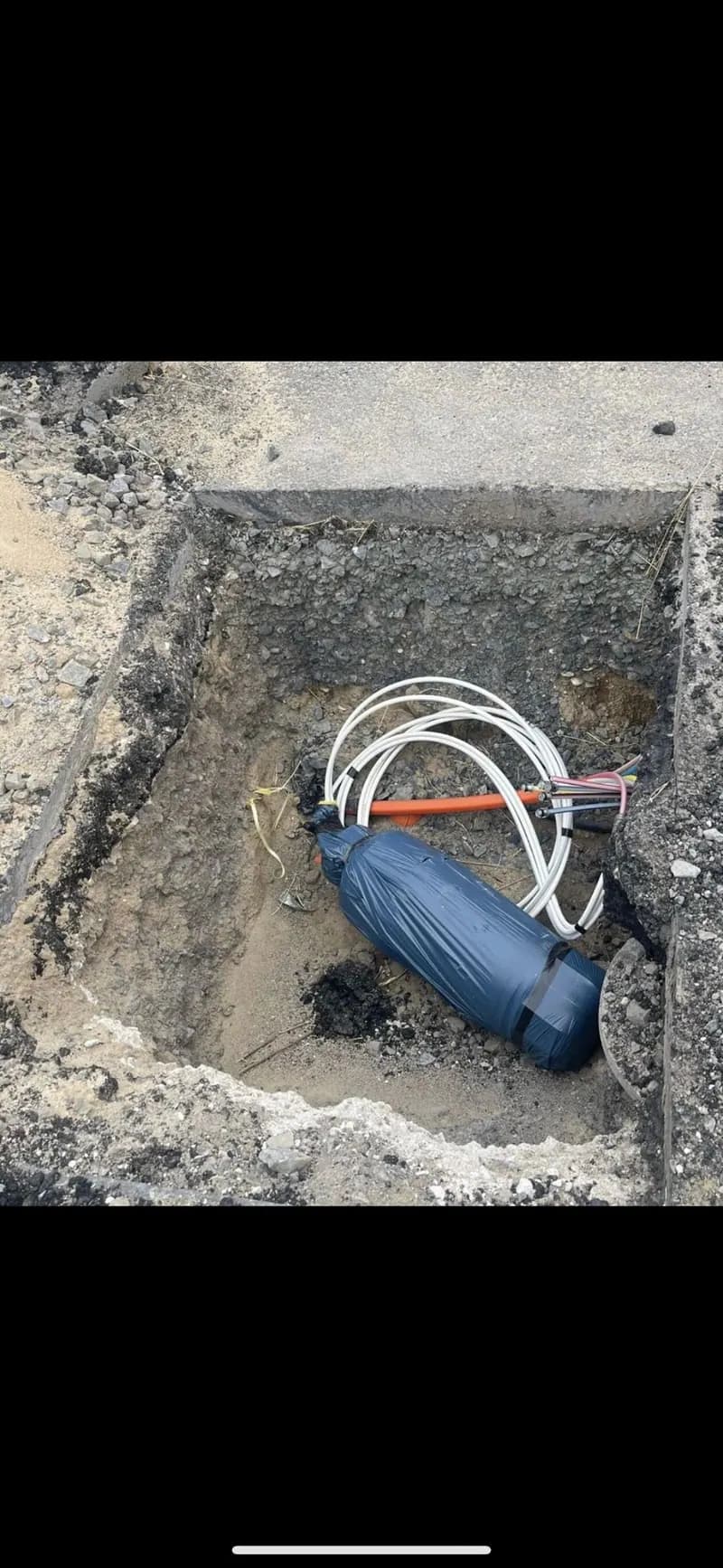 Glasfasermuffe in der offenen Baugrube vor dem Verfüllen