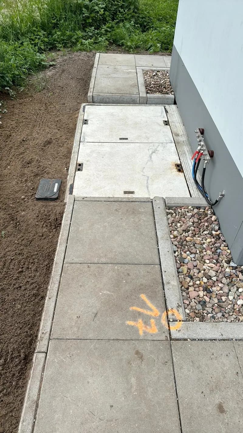 Verlegte Betonplatten mit Trassenmarkierung entlang der Gebäudekante