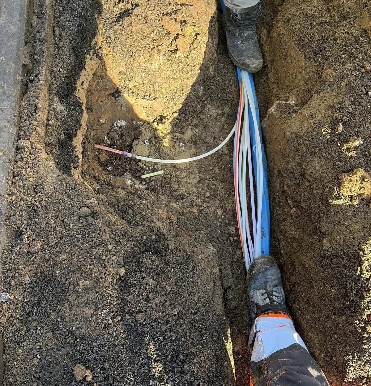 Freigelegte Bestandskabel im offenen Kabelgraben