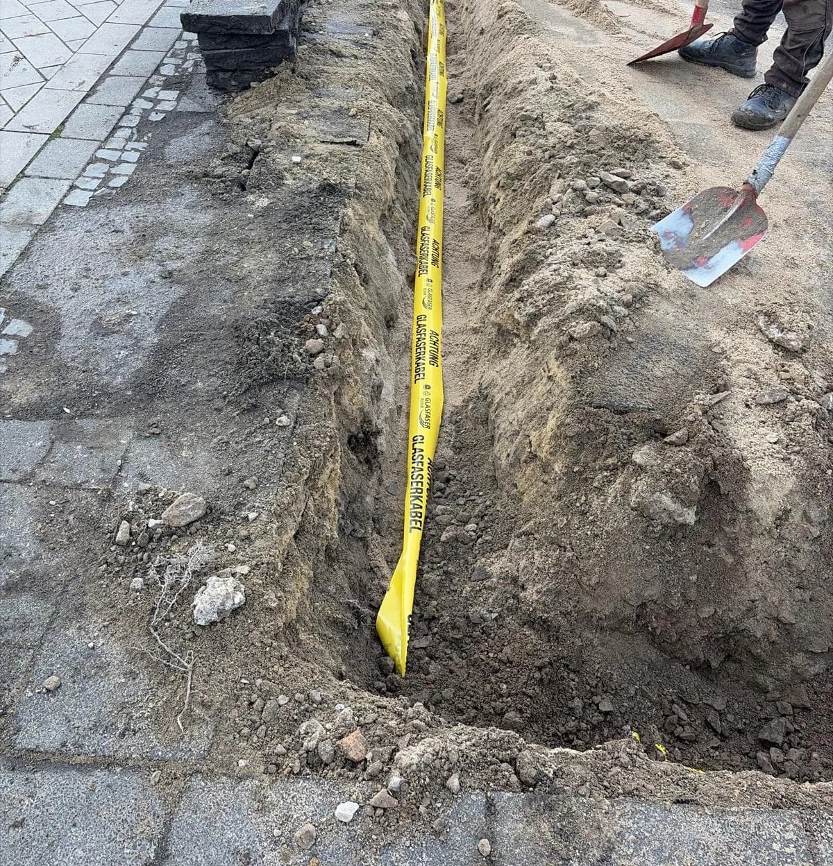 Verfüllbereite Kabeltrasse mit gestapelten Gehwegplatten