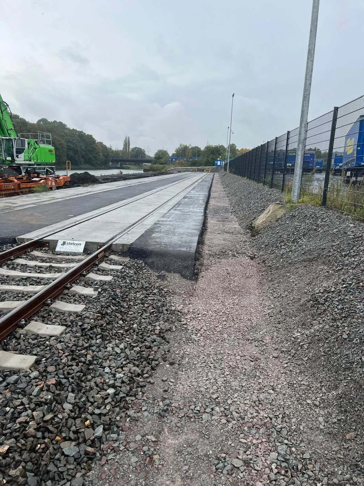 Bahnübergang mit Schotterbett neben dem Gleis vor dem Asphalteinbau