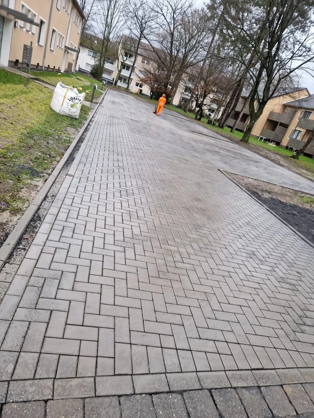 Fertiggestellter Pflasterweg zwischen zwei Wohnhäusern