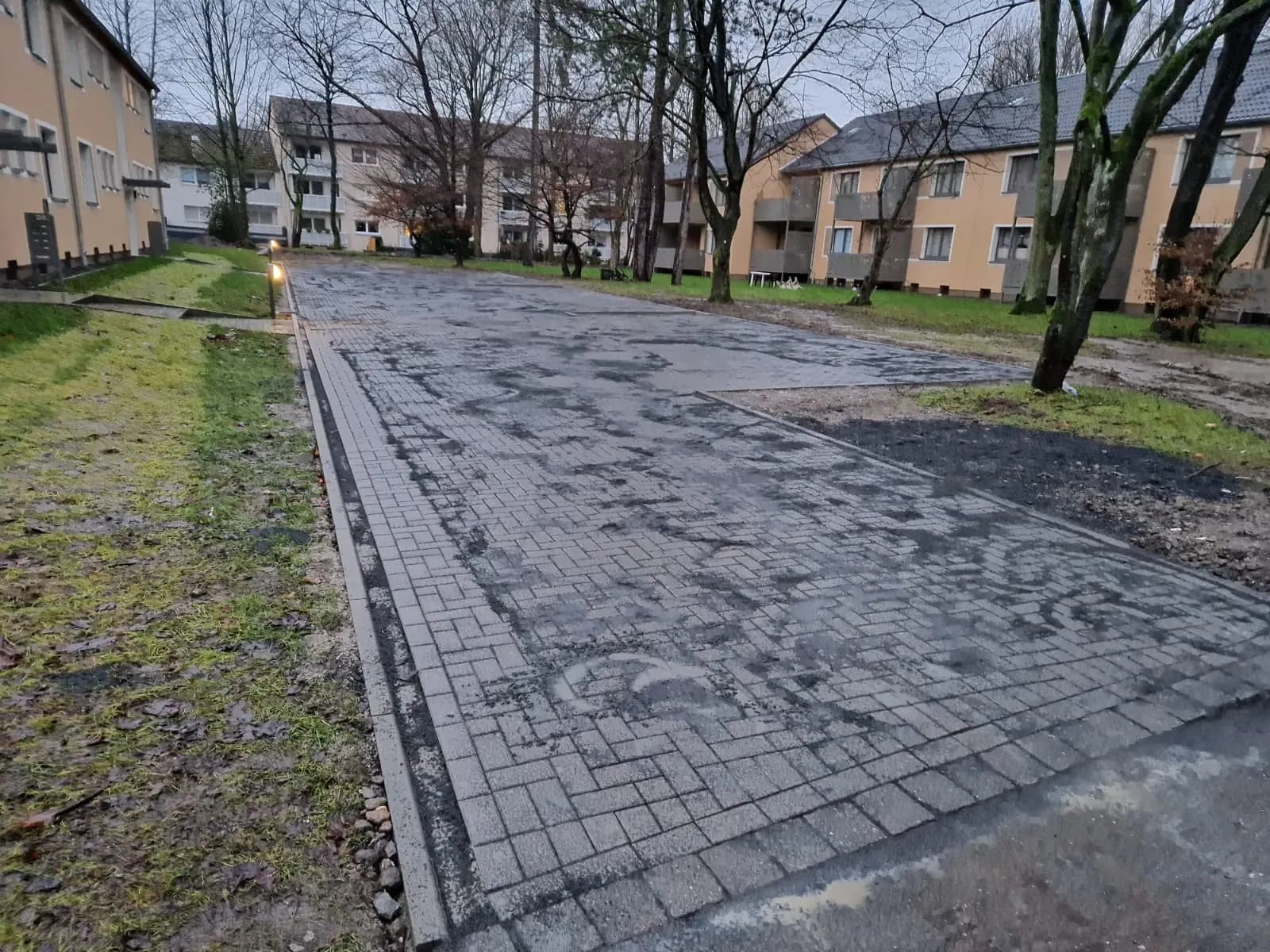 Neu gepflasterter Hofbereich einer Wohnanlage nach Regen