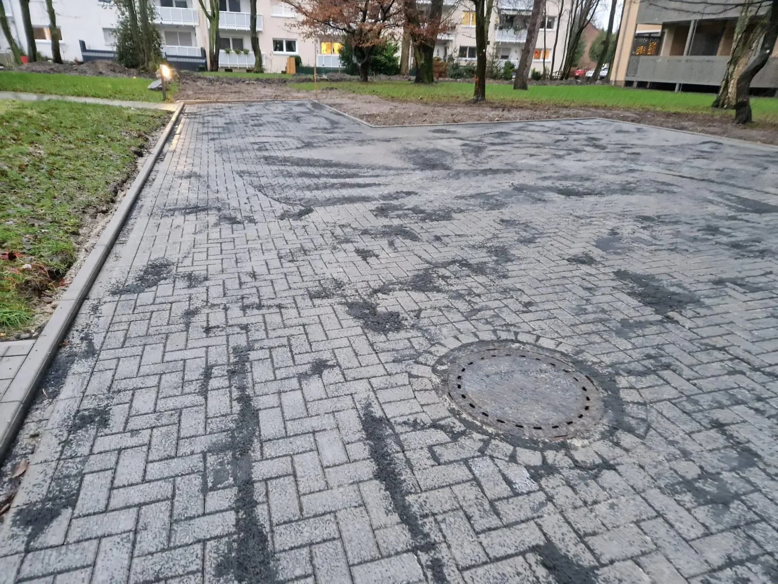 Gepflasterter Weg mit sauber eingebundenem Kanalschacht