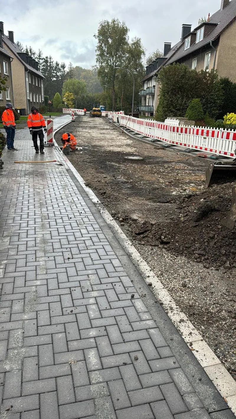 Straßenbaustelle mit Absperrgittern und Team in Warnkleidung