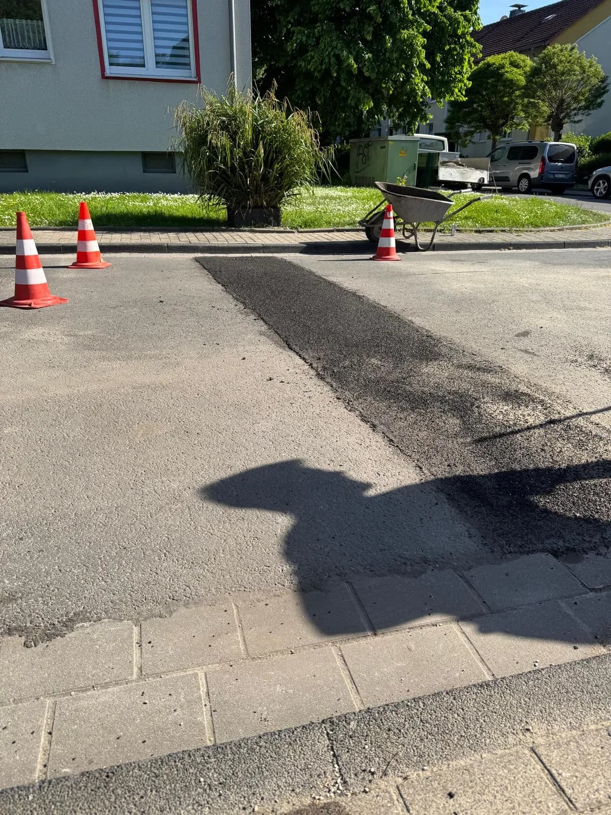 Asphaltausbesserung im Einmündungsbereich einer Wohnstraße