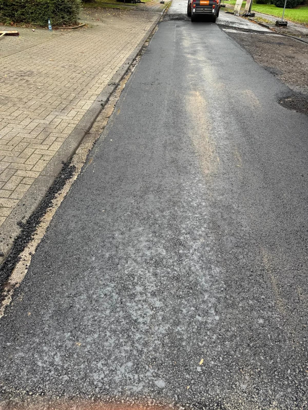 Neu eingebaute Asphaltschicht auf einer Straße im Wohngebiet