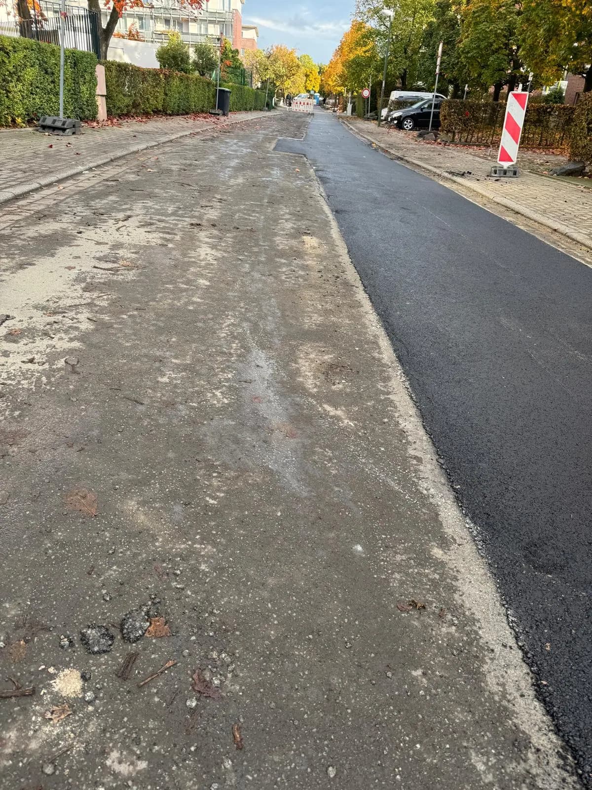 Neu asphaltierter Streifen neben der noch gefrästen Fahrbahn