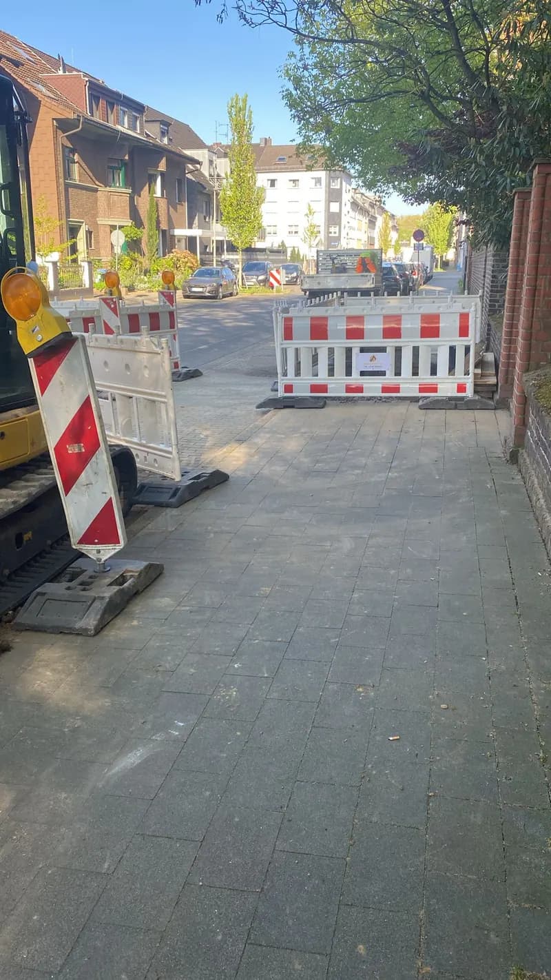 Absperrbaken sichern eine Straßenbaustelle im Wohngebiet