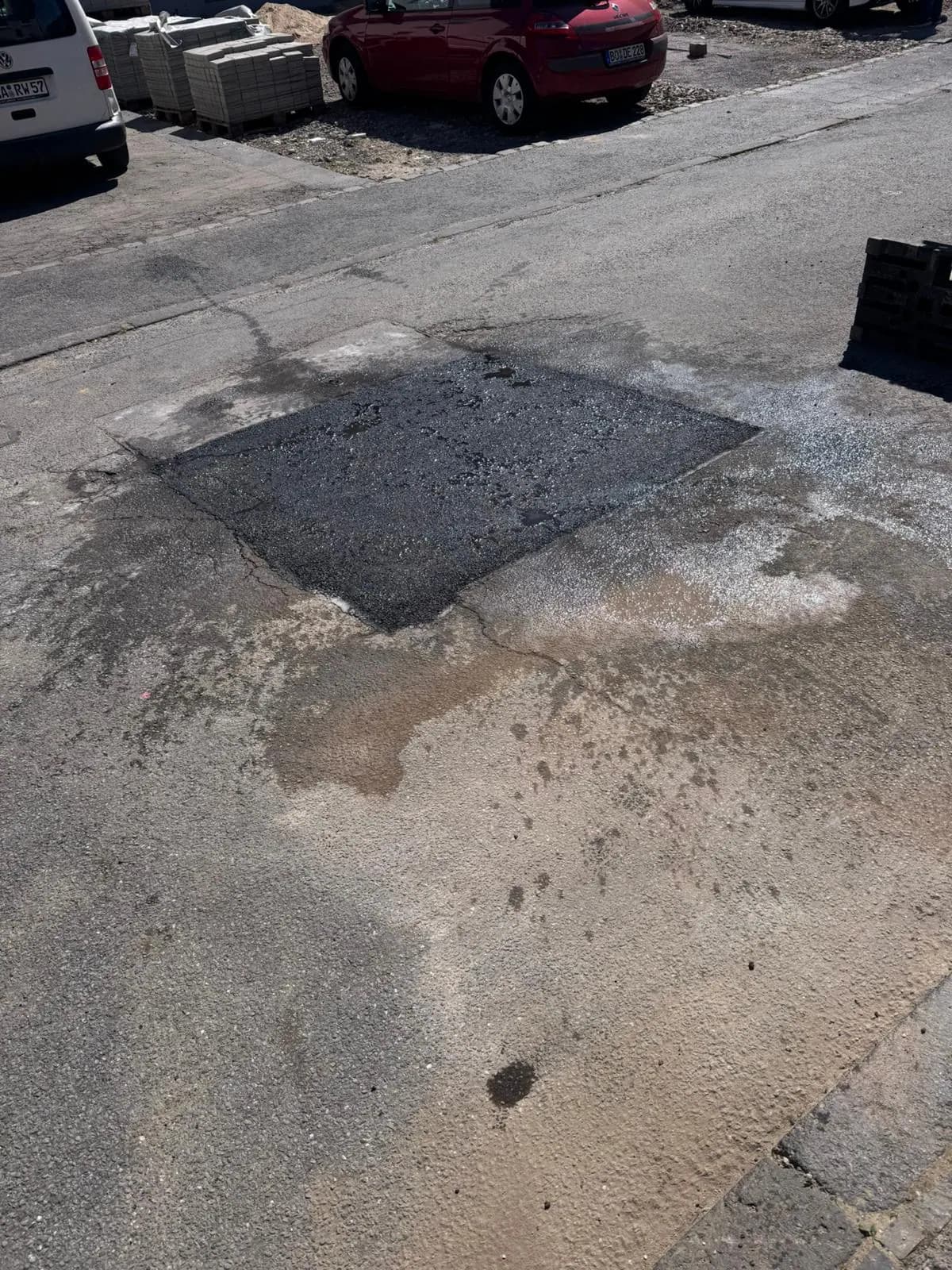 Asphaltausbesserung an einer Parkbucht in einer Wohnstraße