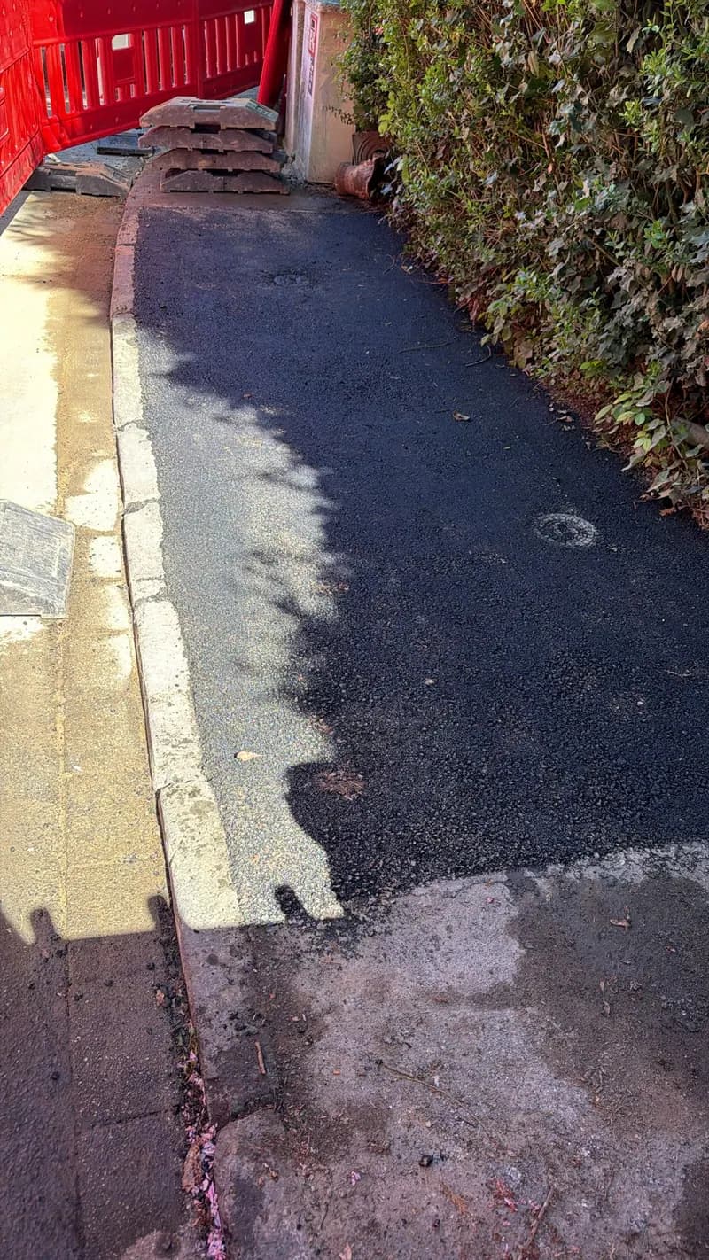 Frisch verfüllter Leitungsgraben entlang eines Gehwegs