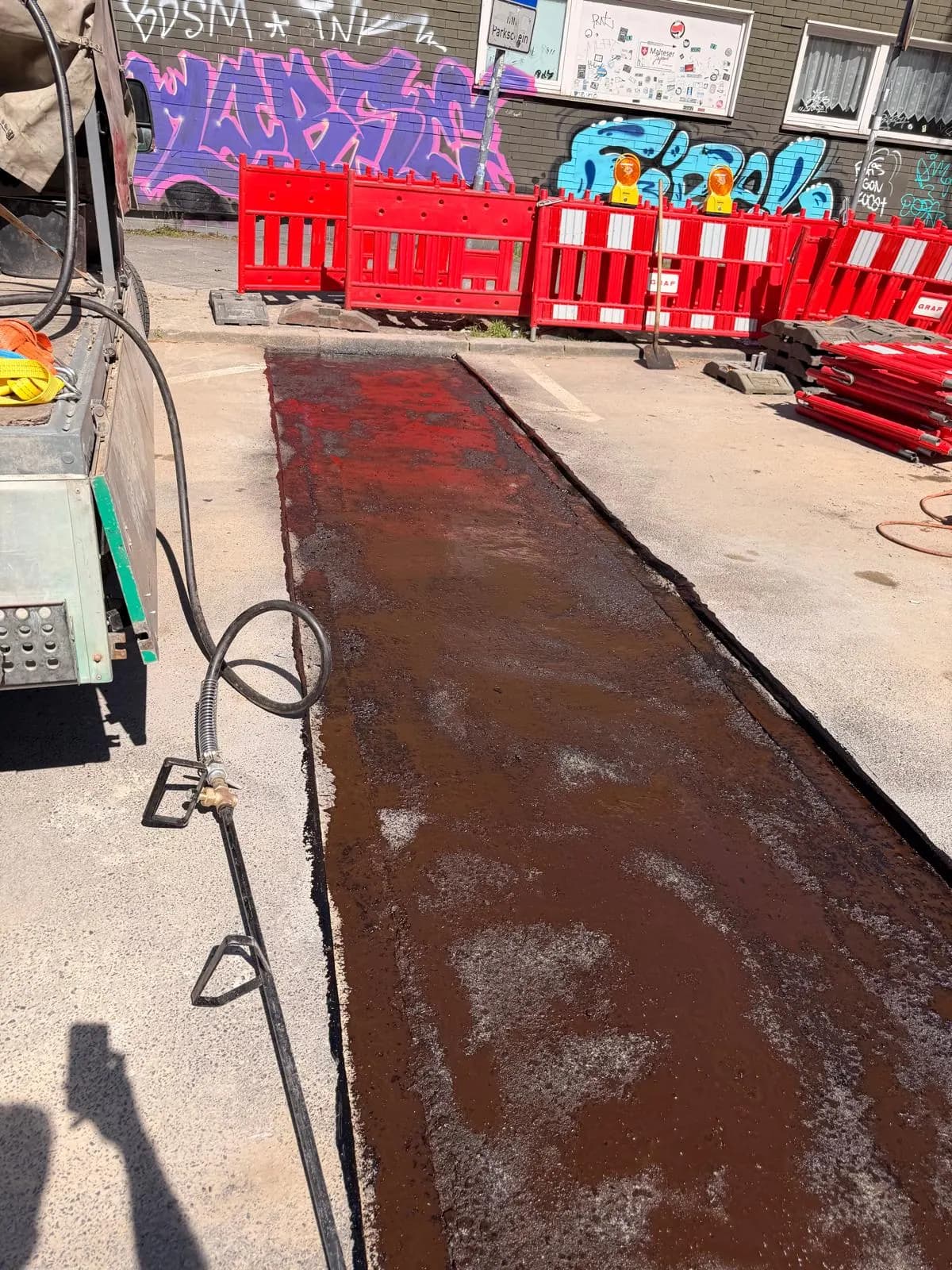 Mit Bitumenemulsion vorbehandelter Straßenabschnitt vor dem Asphalteinbau