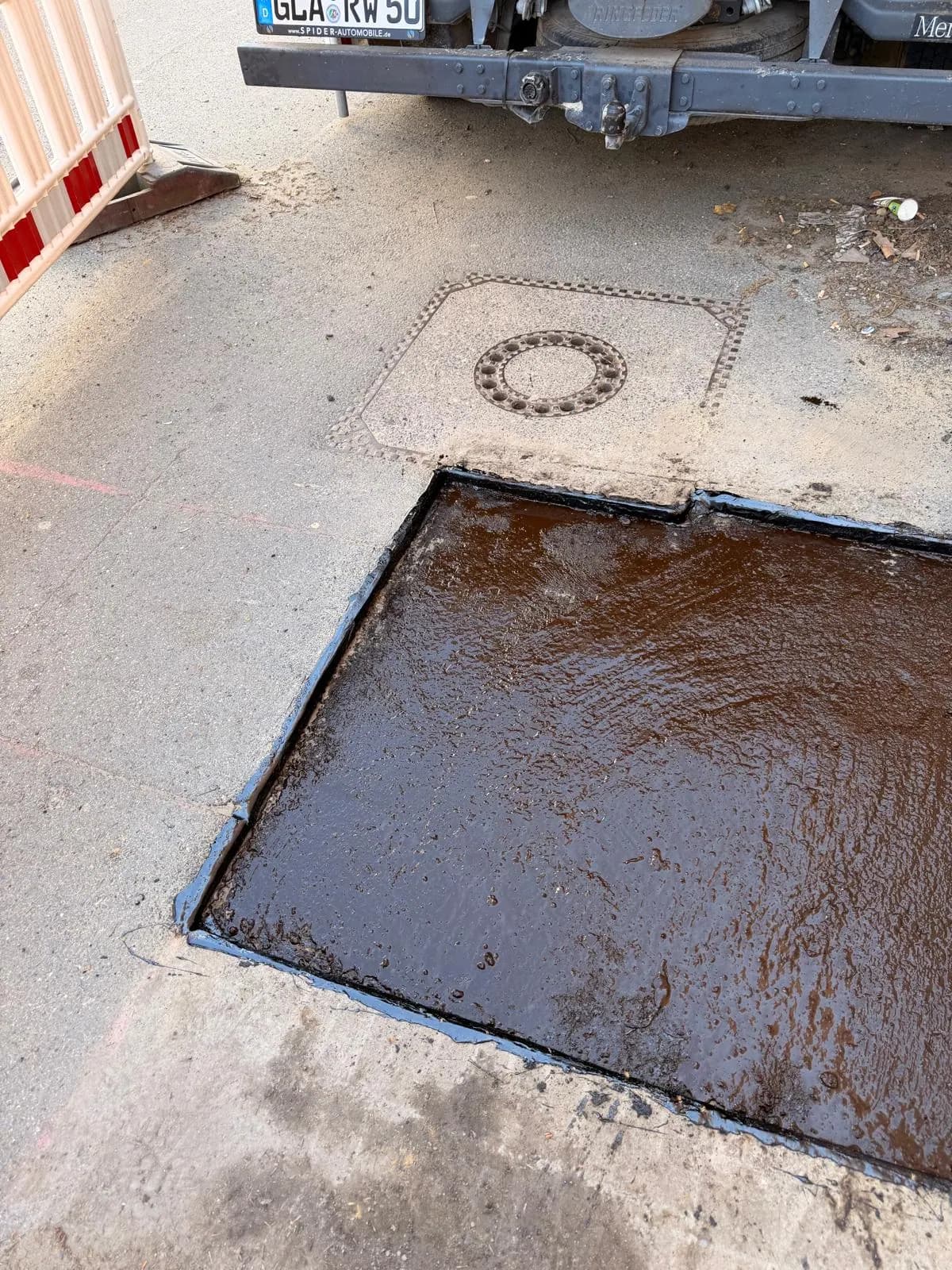 Detail einer frisch eingebundenen Schachtabdeckung in der Straßendecke