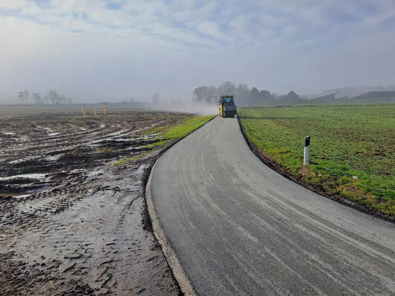 Neu gebauter Weg führt in geschwungener Linie durch Ackerland