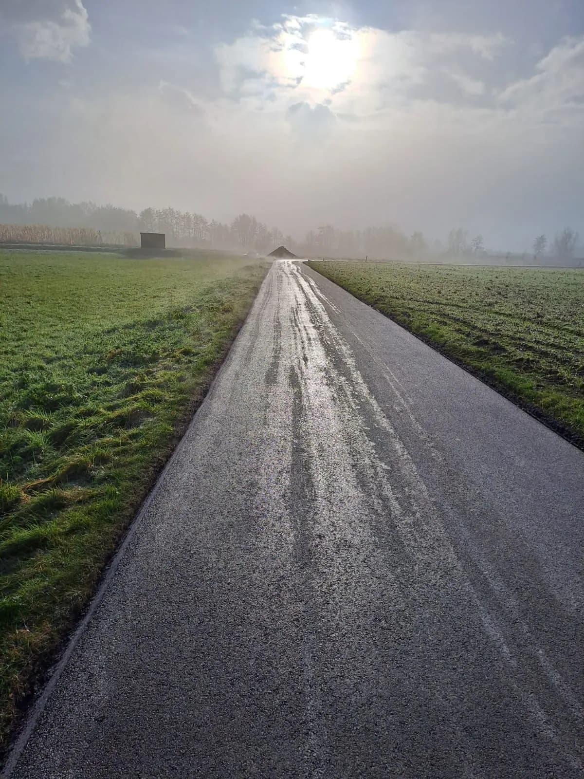 Fertiggestellter Weg zwischen Feldern in der Morgensonne