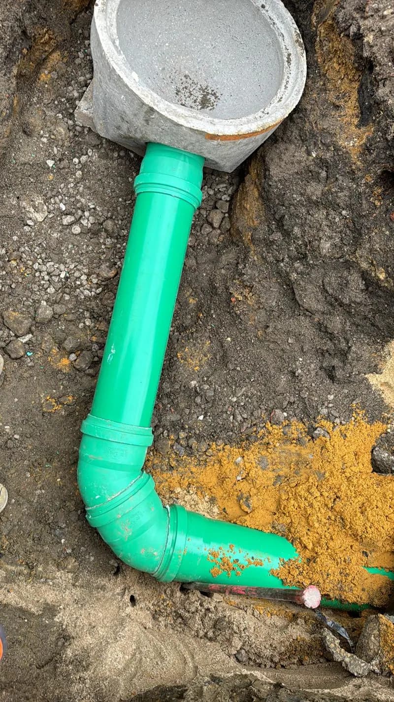 Grüner Rohrbogen mit Anschluss an ein Schachtbauwerk