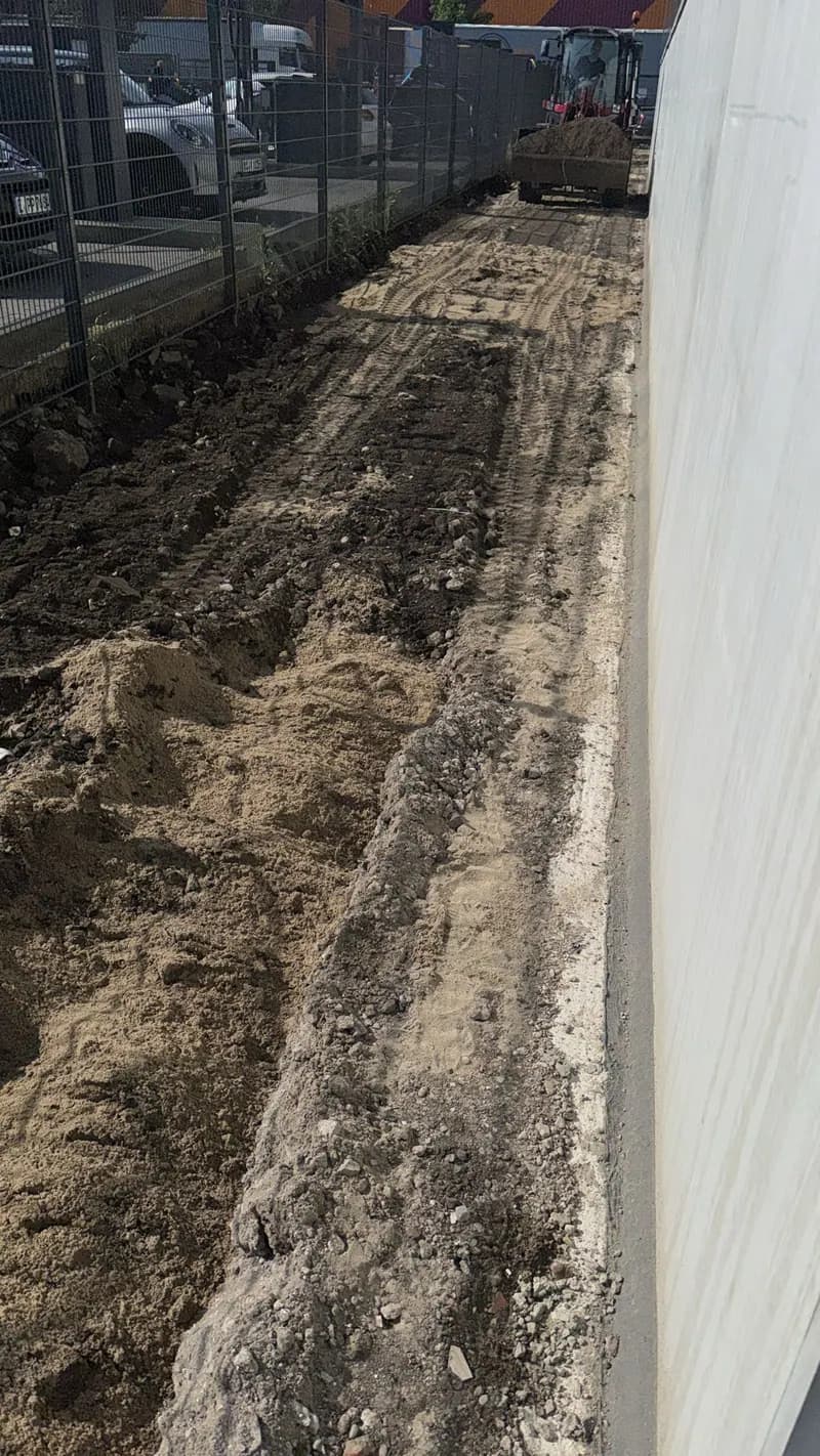 Ausgehobener Graben entlang der Fassade eines Neubaus